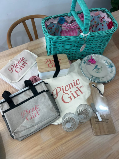 Picnic Girl teal wicker basket set with floral lining, insulated cooler bag, bamboo board, and vintage-style plates.